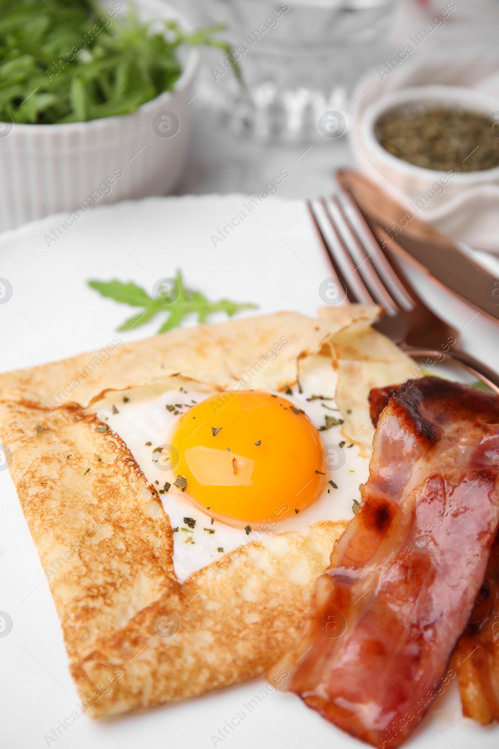 Photo of Delicious crepe with egg served on table, closeup. Breton galette