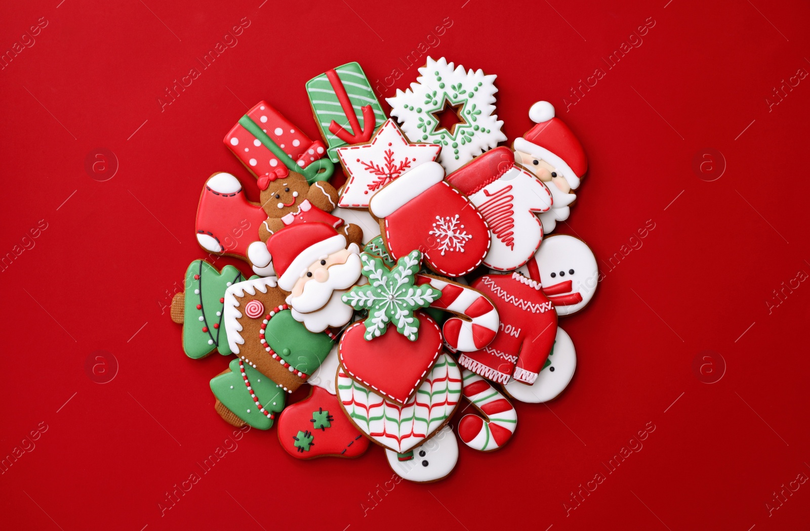 Photo of Different Christmas gingerbread cookies on red background, flat lay