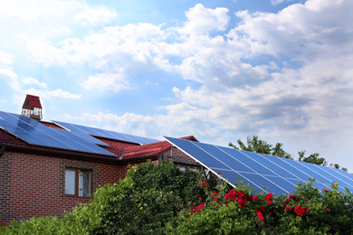 Photo of House with installed solar panels on roof. Alternative energy source