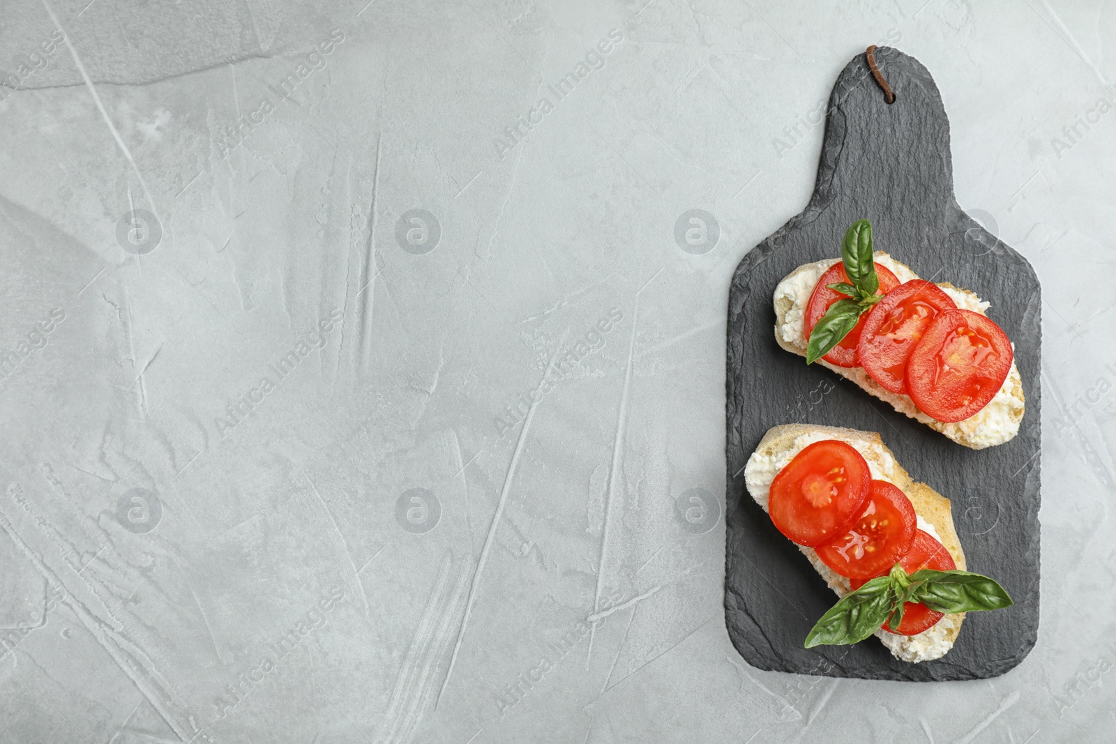 Photo of Tasty fresh tomato bruschettas on grey table, flat lay. Space for text