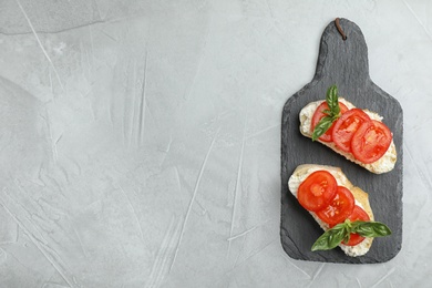 Photo of Tasty fresh tomato bruschettas on grey table, flat lay. Space for text