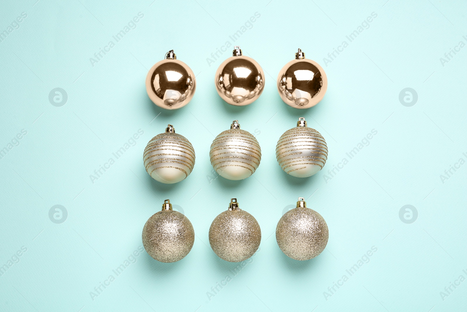 Photo of Shiny Christmas balls on light blue background, flat lay