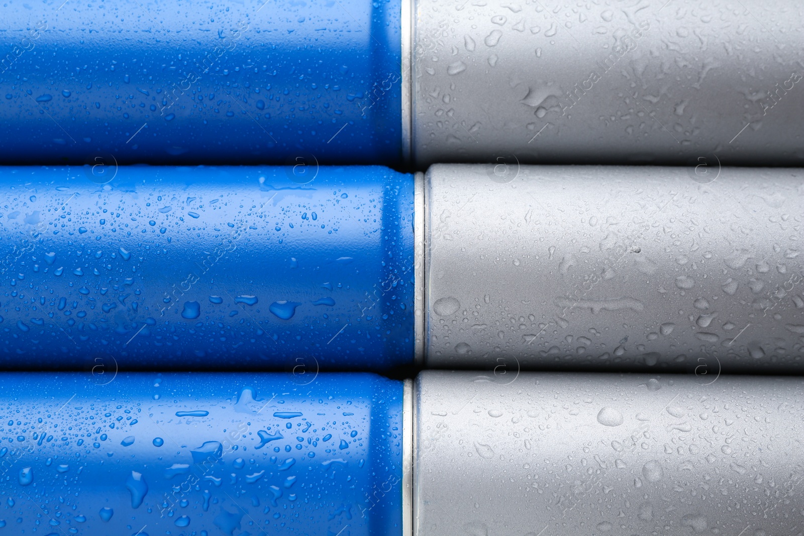 Photo of Energy drinks in wet cans as background, top view