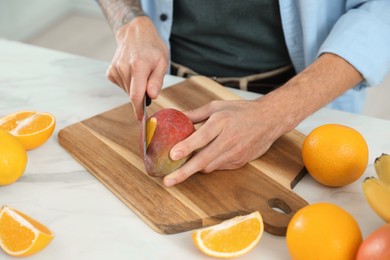 Photo of Man preparing ingredients for tasty smoothie at white marble table in kitchen, closeup