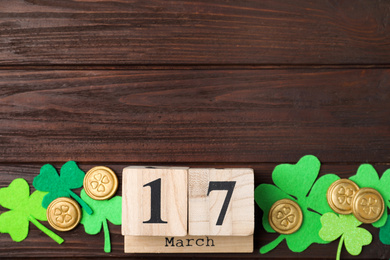 Flat lay composition with block calendar on wooden background, space for text. St. Patrick's Day celebration