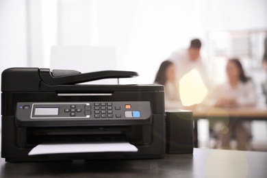 Photo of New modern printer on table in office. Space for text