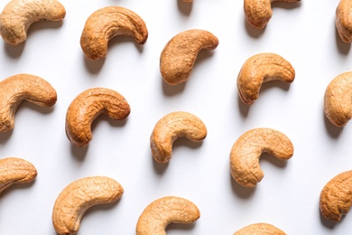 Tasty roasted cashew nuts on white background, top view