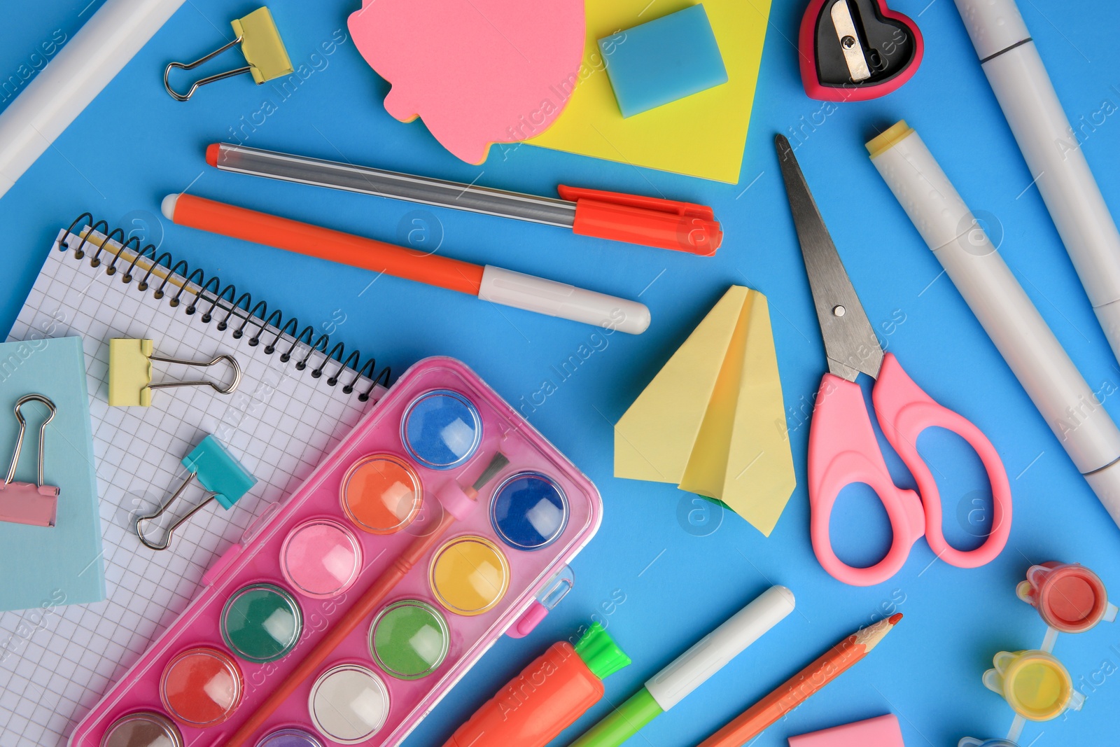 Photo of Flat lay composition with notebook and other school stationery on light blue background. Back to school