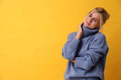 Photo of Happy woman in stylish sweater on yellow background. Space for text