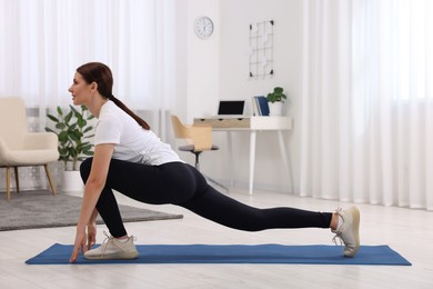 Photo of Morning routine. Happy woman doing stretching exercise at home