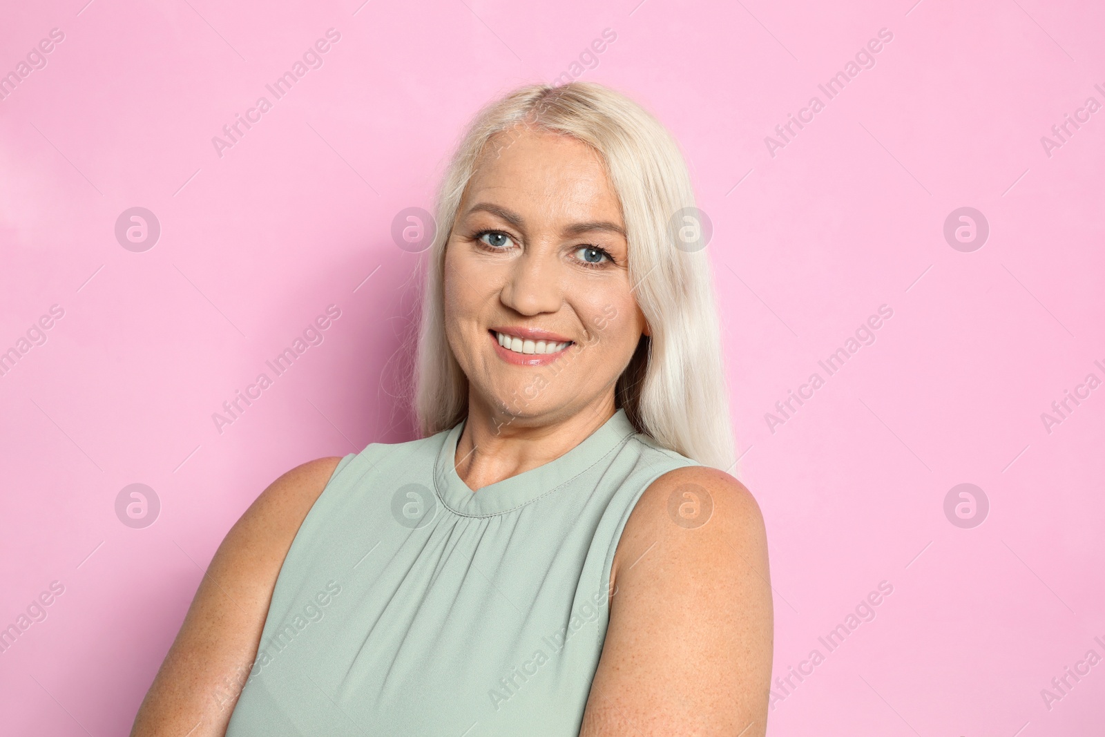 Photo of Portrait of mature woman with beautiful face on pink background