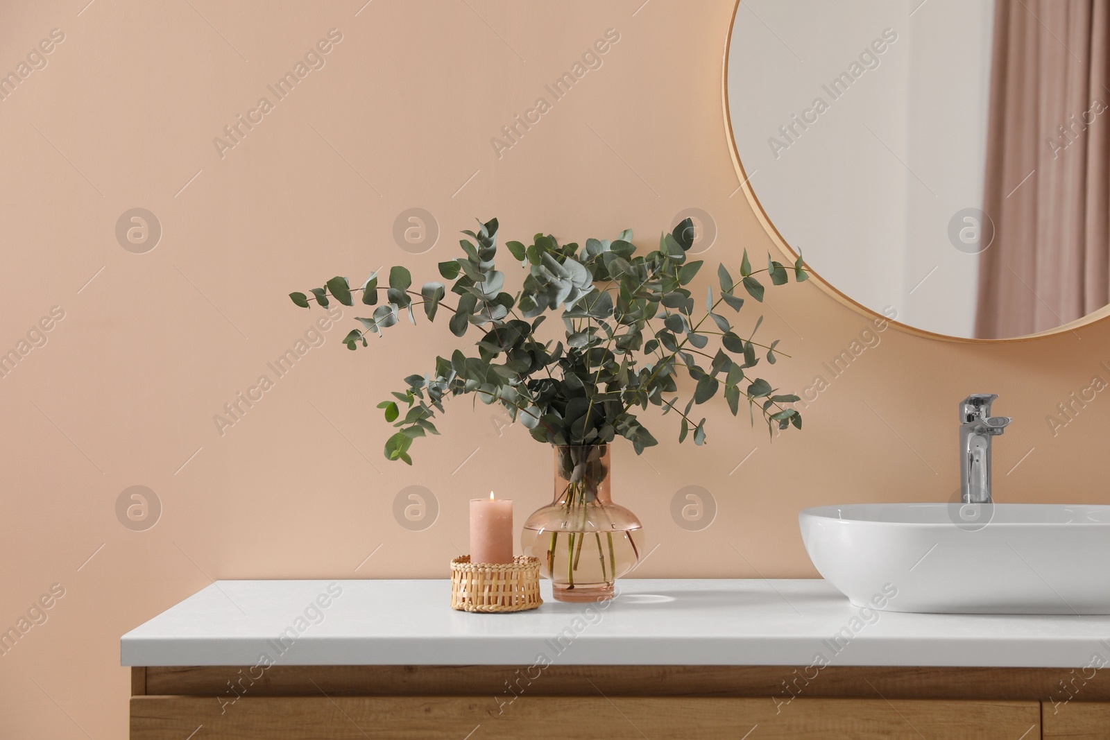 Photo of Stylish mirror, eucalyptus branches and vessel sink in modern bathroom. Interior design