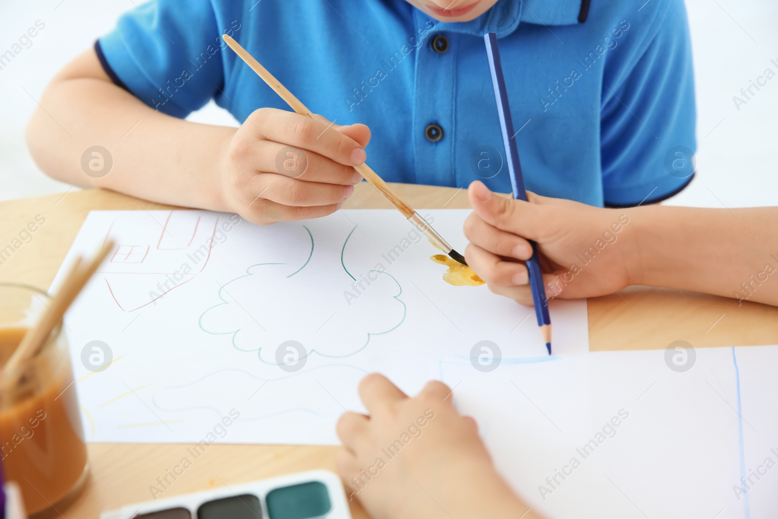 Photo of Cute little children painting at table in playing room