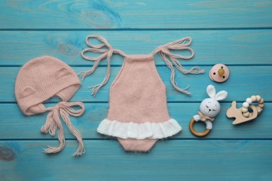 Photo of Flat lay composition with cute baby knitwear for photoshoot on light blue wooden background
