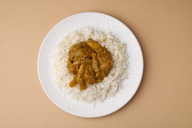 Photo of Delicious chicken curry with rice on beige background, top view