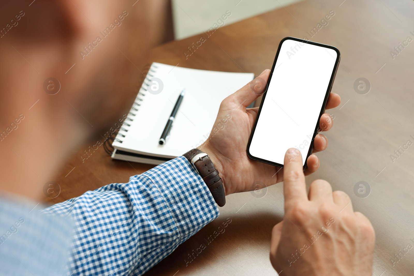 Photo of Man using smartphone at table, closeup view