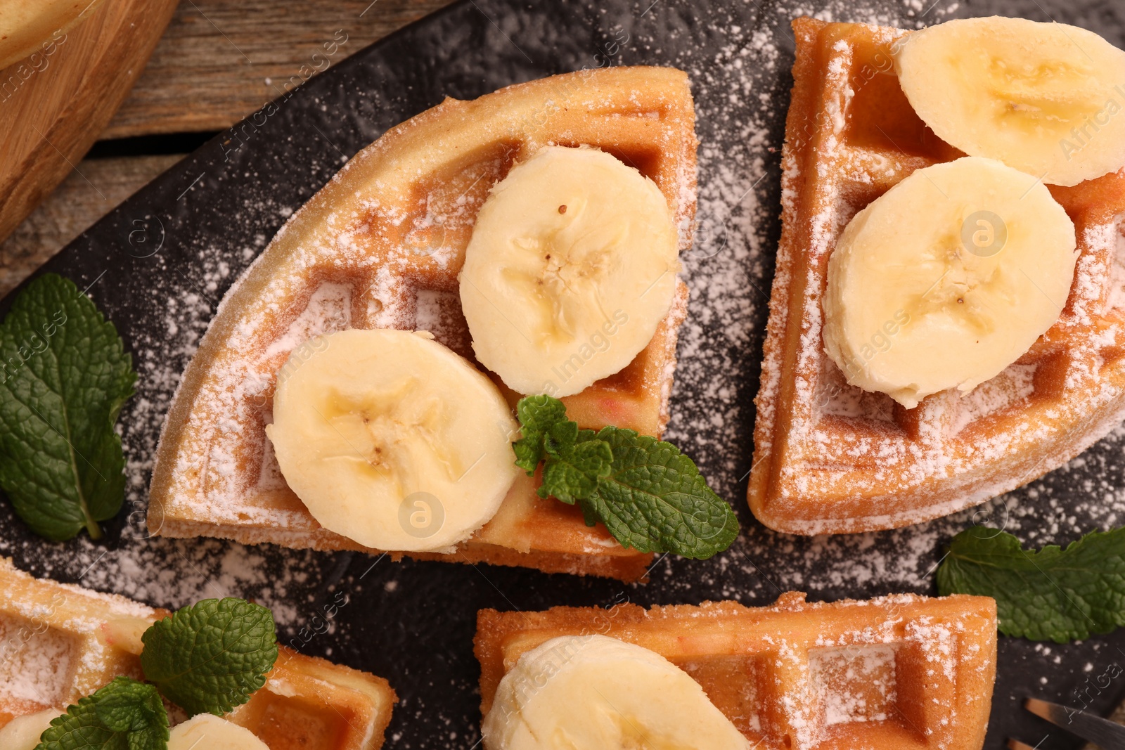 Photo of Tasty Belgian waffles with banana and mint on table, top view