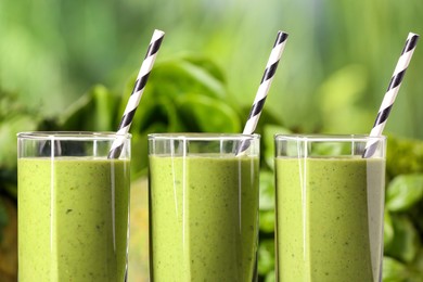 Photo of Fresh green smoothie and ingredients on blurred background, closeup