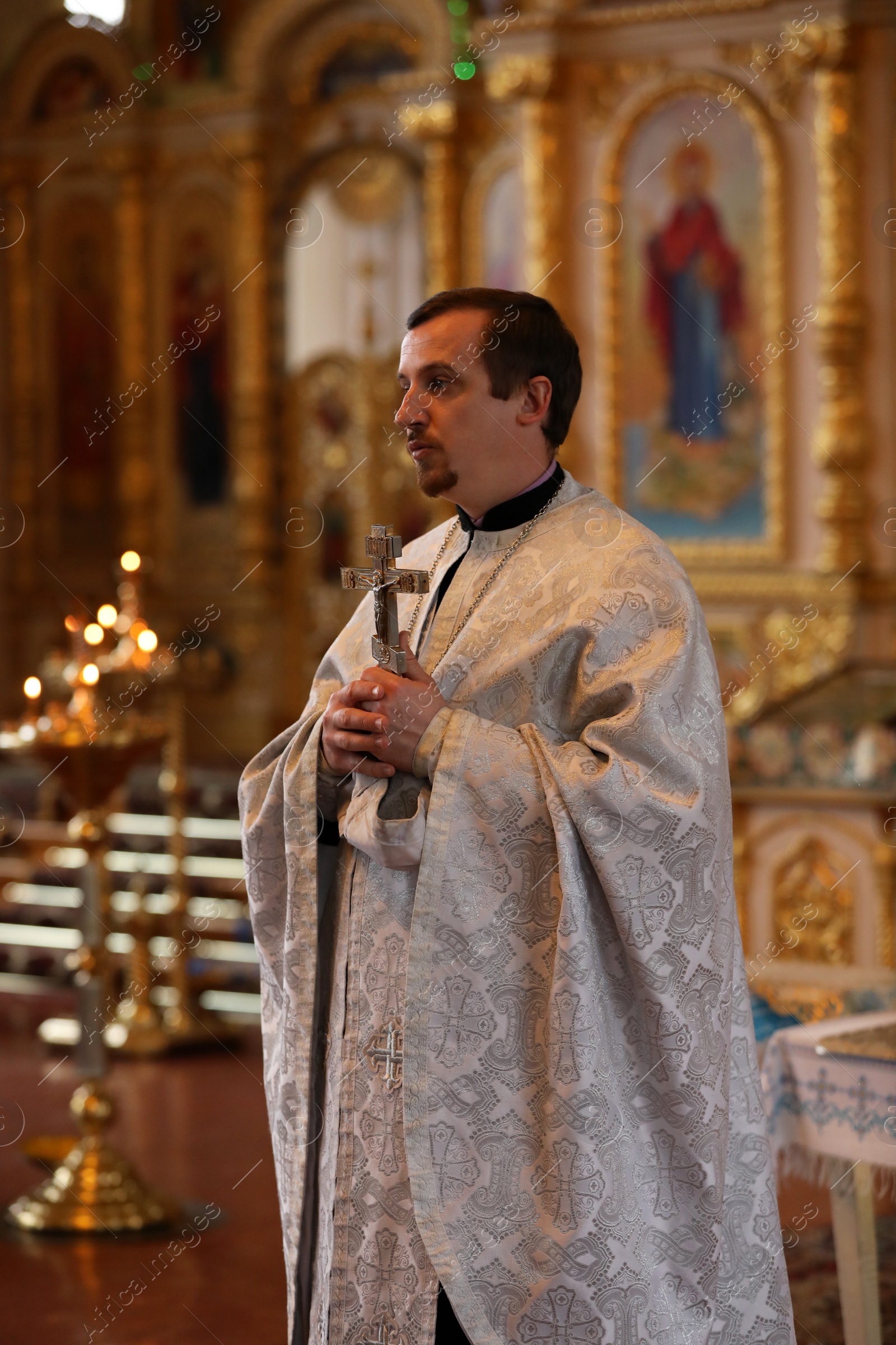 Photo of MYKOLAIV, UKRAINE - FEBRUARY 27, 2021: Priest with cross conducting baptism ceremony in Kasperovskaya icon of Mother of God cathedral