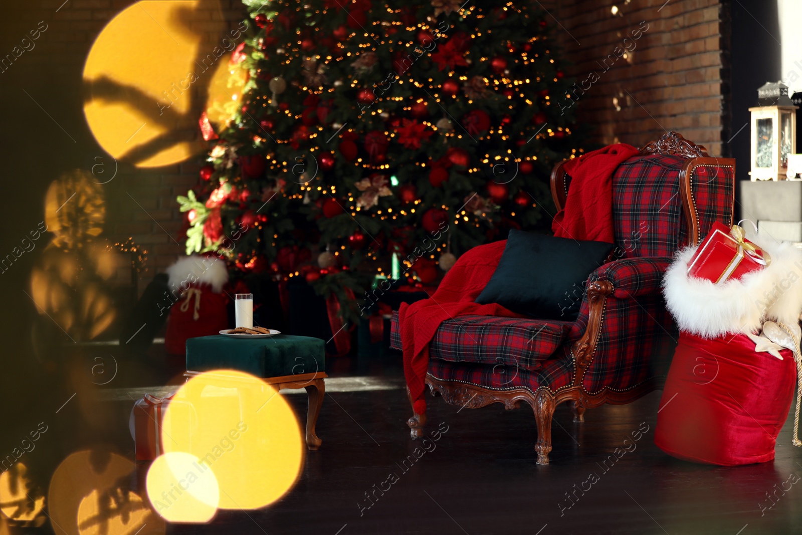 Photo of Santa Claus bag near armchair in room with Christmas tree