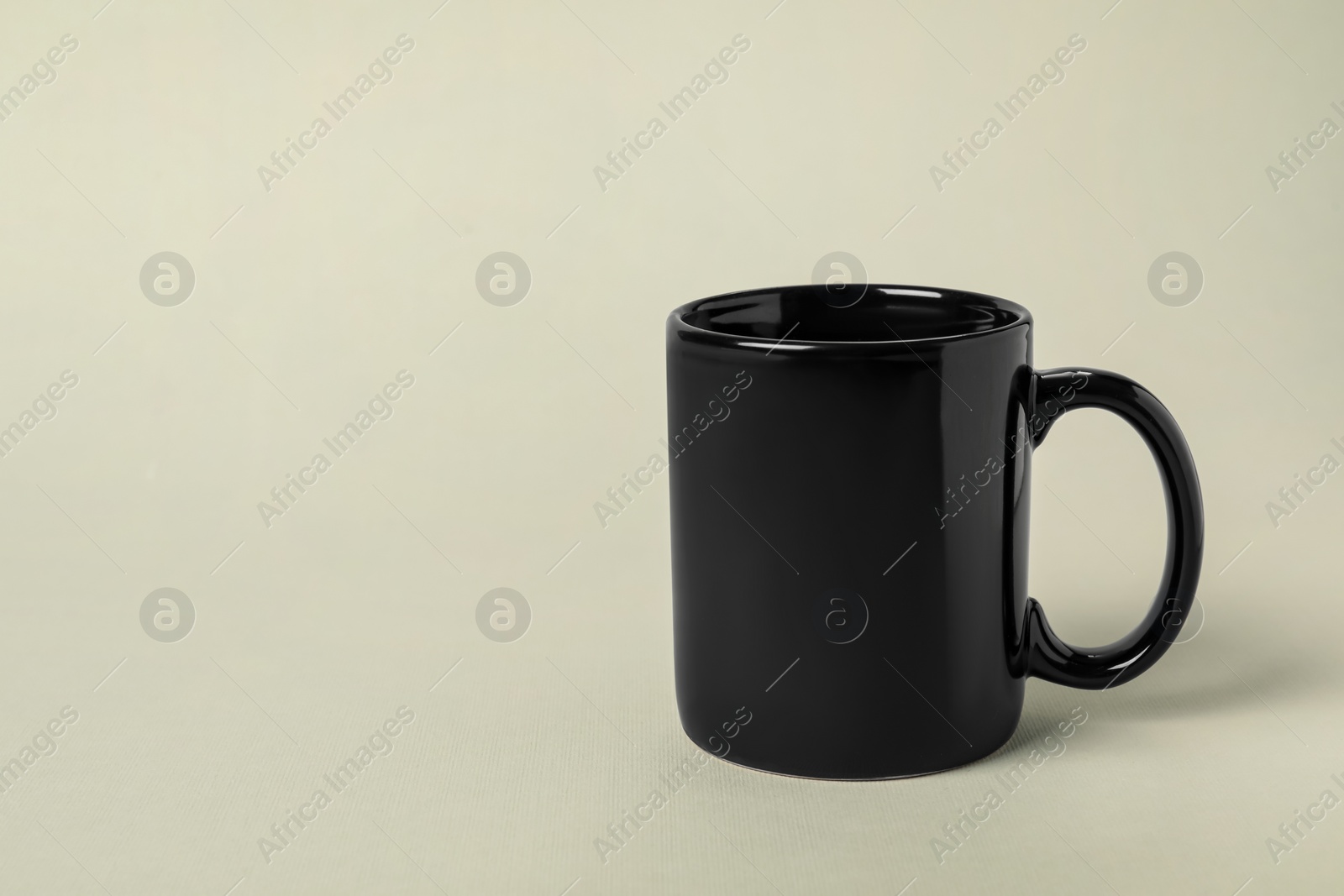 Photo of One black ceramic mug on light grey background, space for text