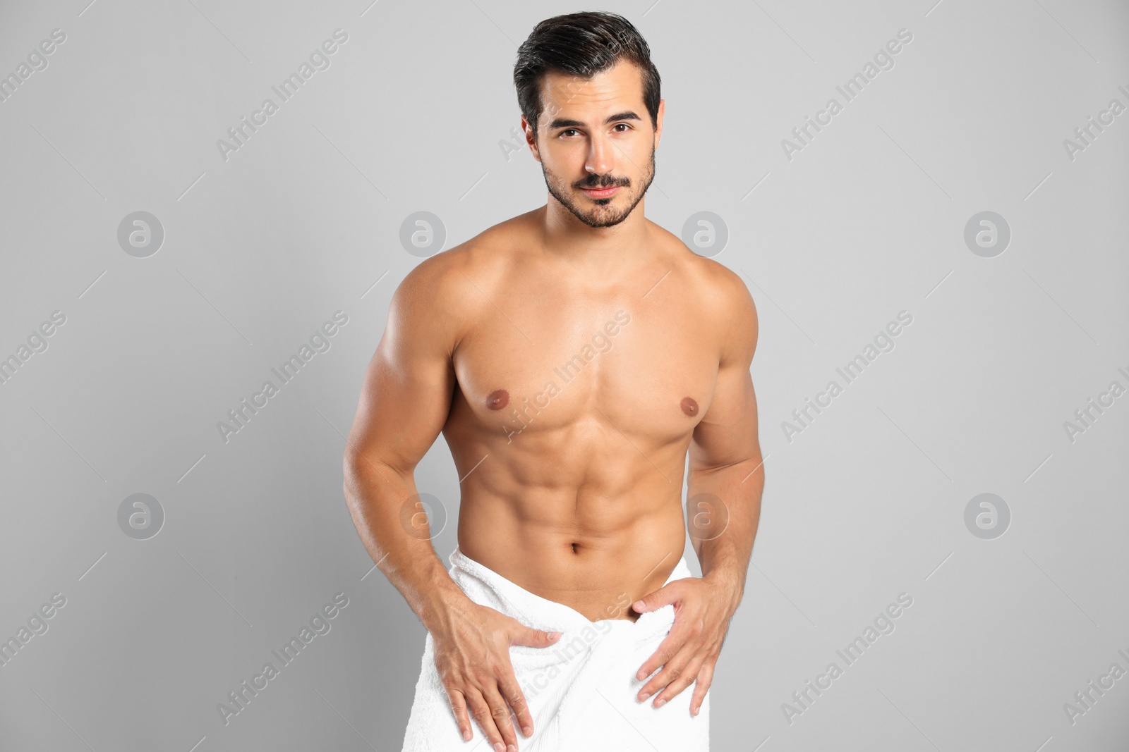 Photo of Young man with slim body on grey background