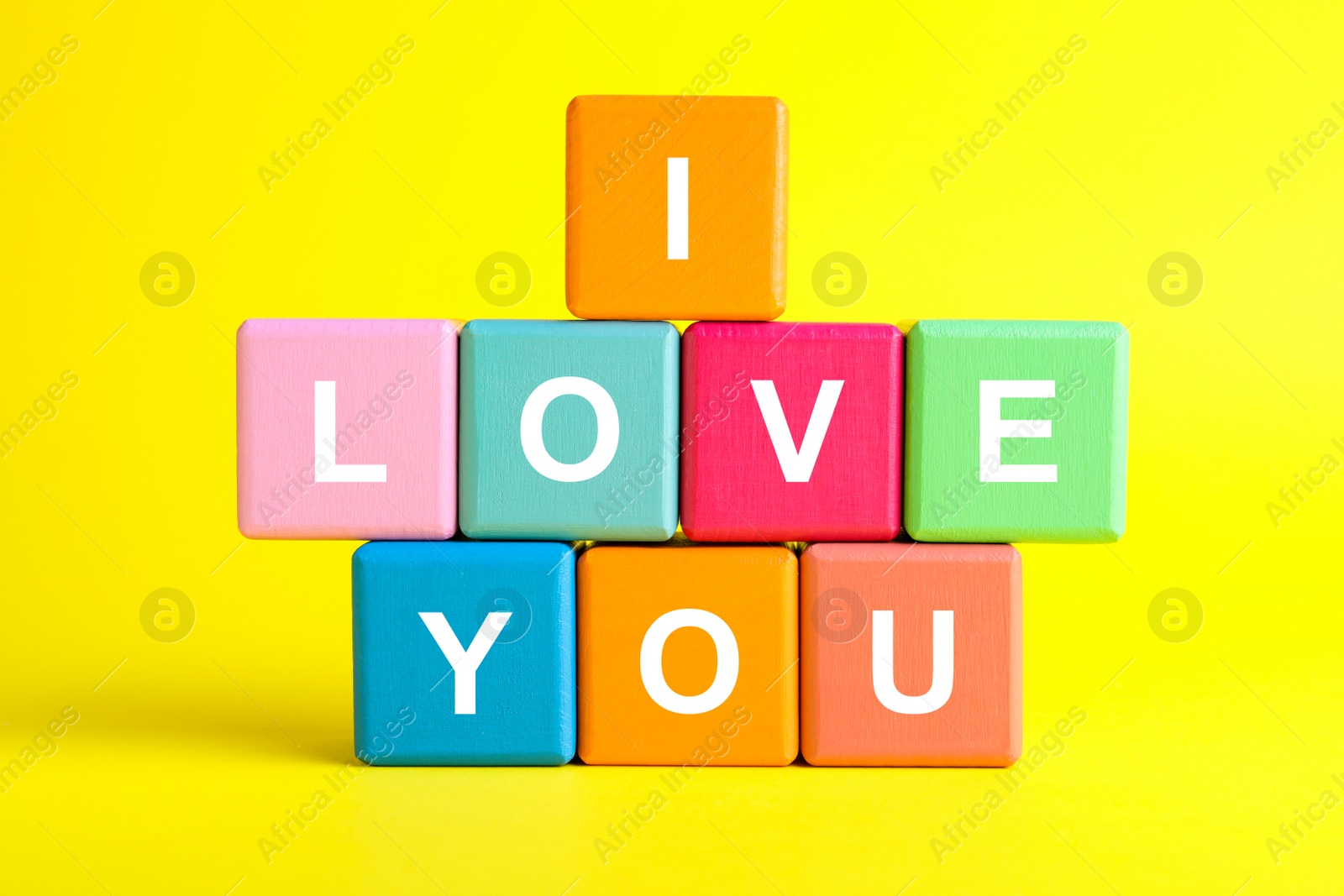 Photo of Colorful cubes with words I Love You on yellow background