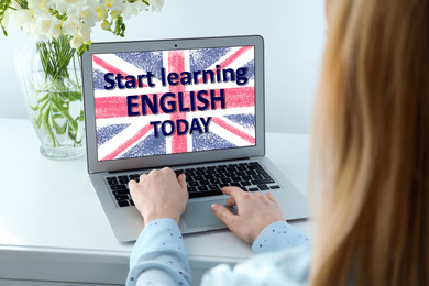 Young woman using laptop for online English learning at home, closeup