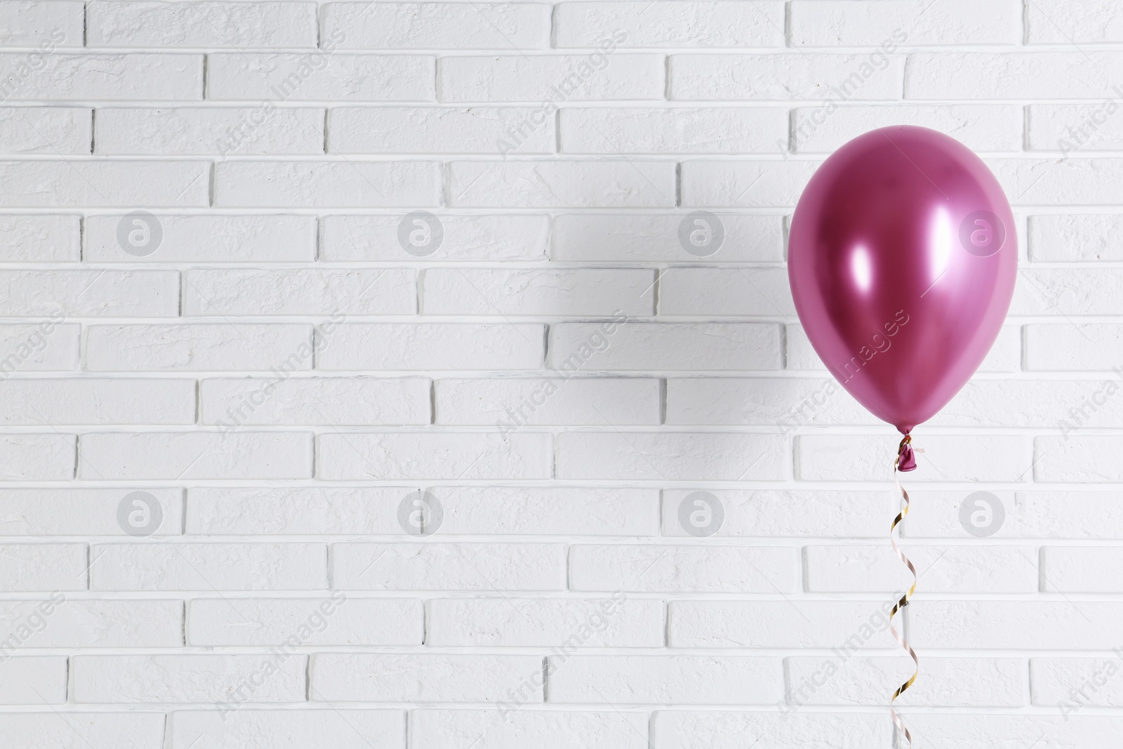 Photo of Bright balloon near brick wall, space for text. Party time