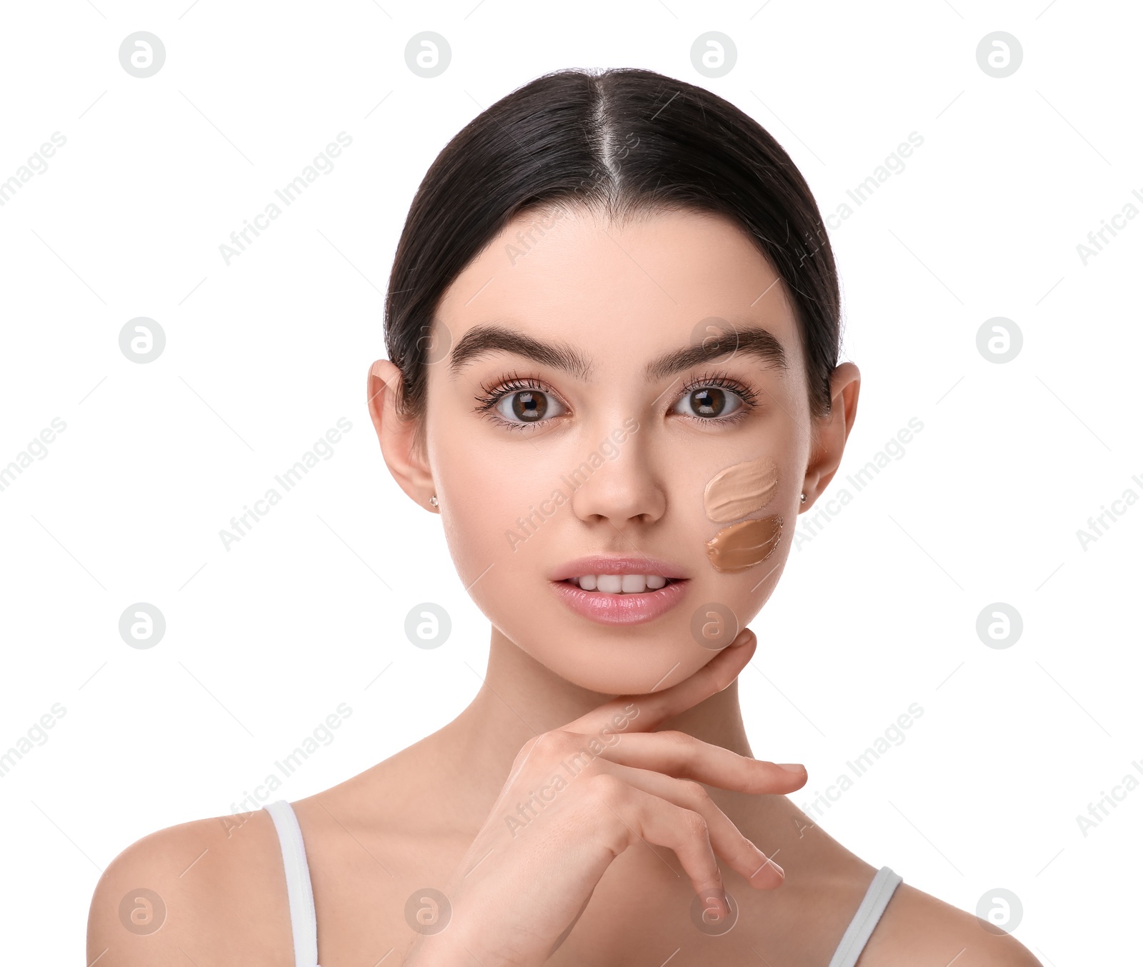 Photo of Teenage girl with swatches of foundation on face against white background