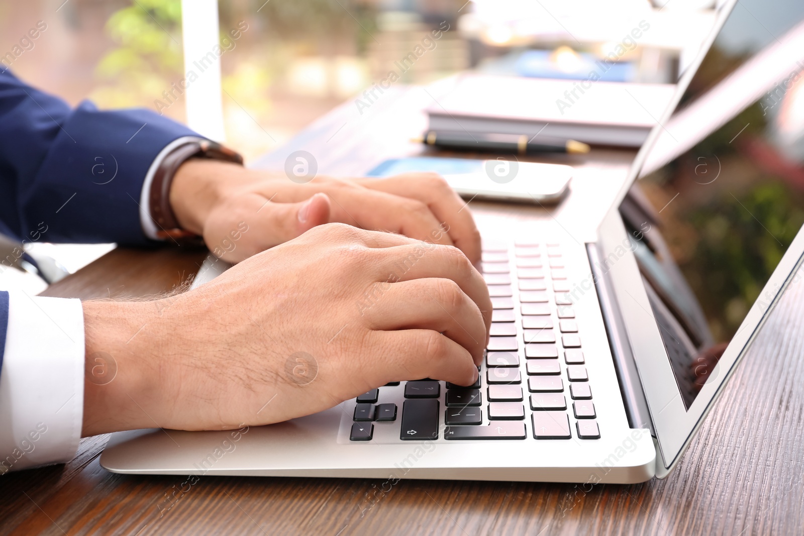 Photo of Lawyer working with laptop at table, focus on hands