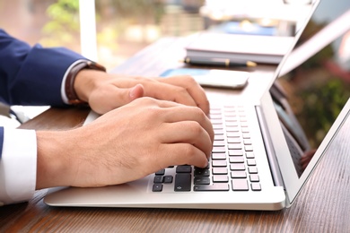 Lawyer working with laptop at table, focus on hands