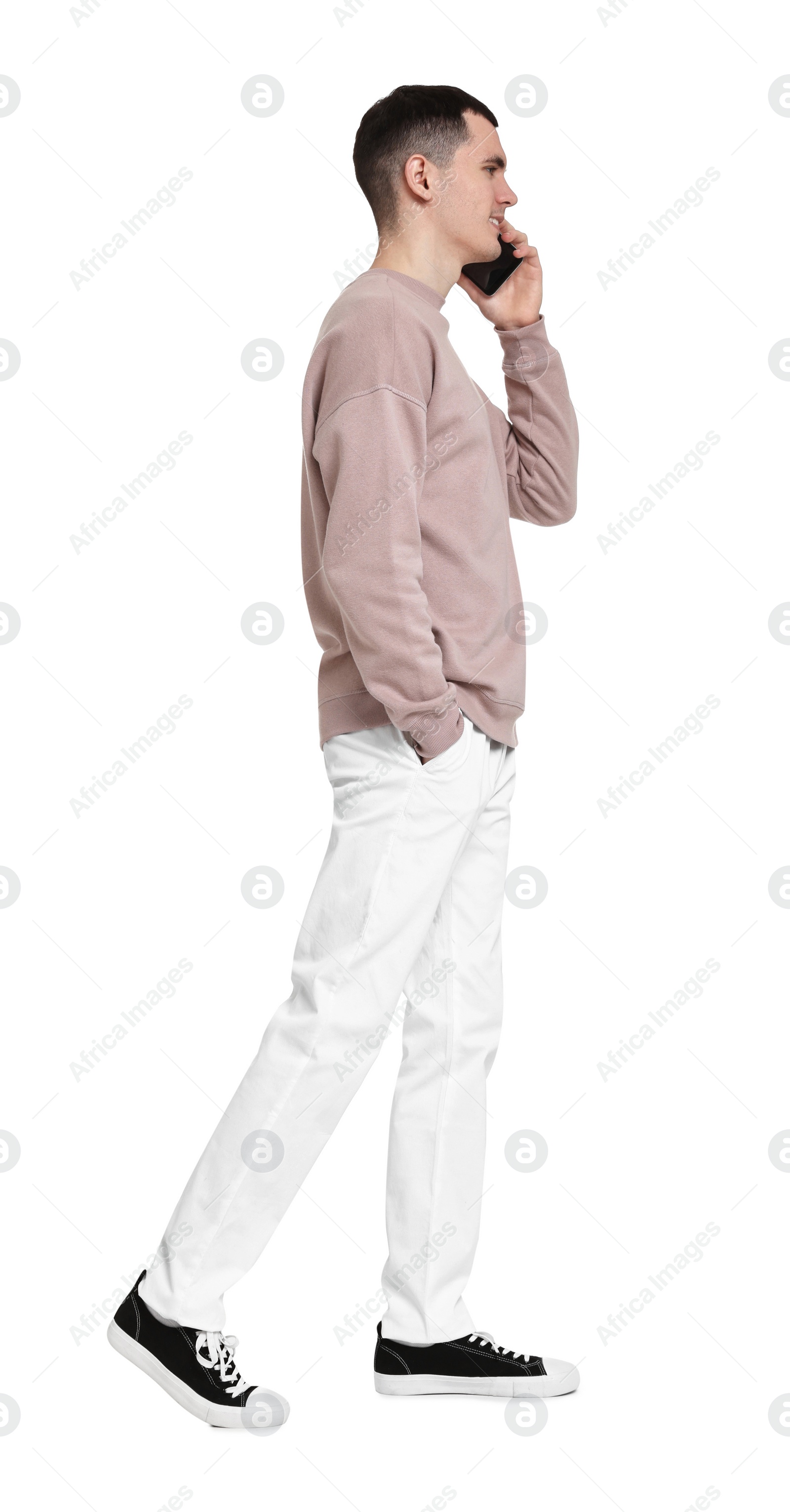 Photo of Handsome young man talking on phone against white background