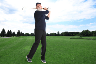 Image of Senior man playing golf on course with green grass. Space for design