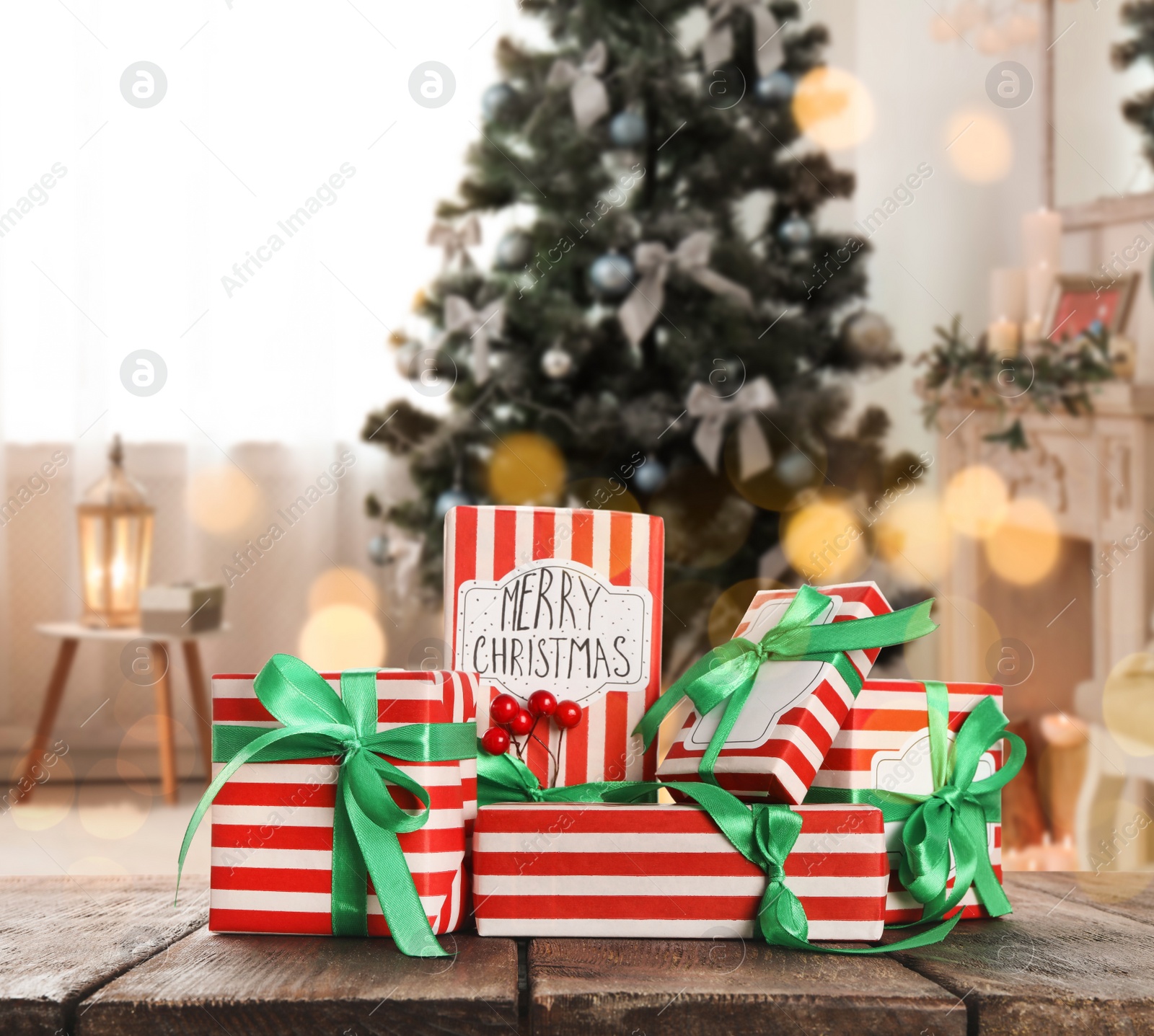 Image of Christmas gift boxes on wooden table in room, bokeh effect