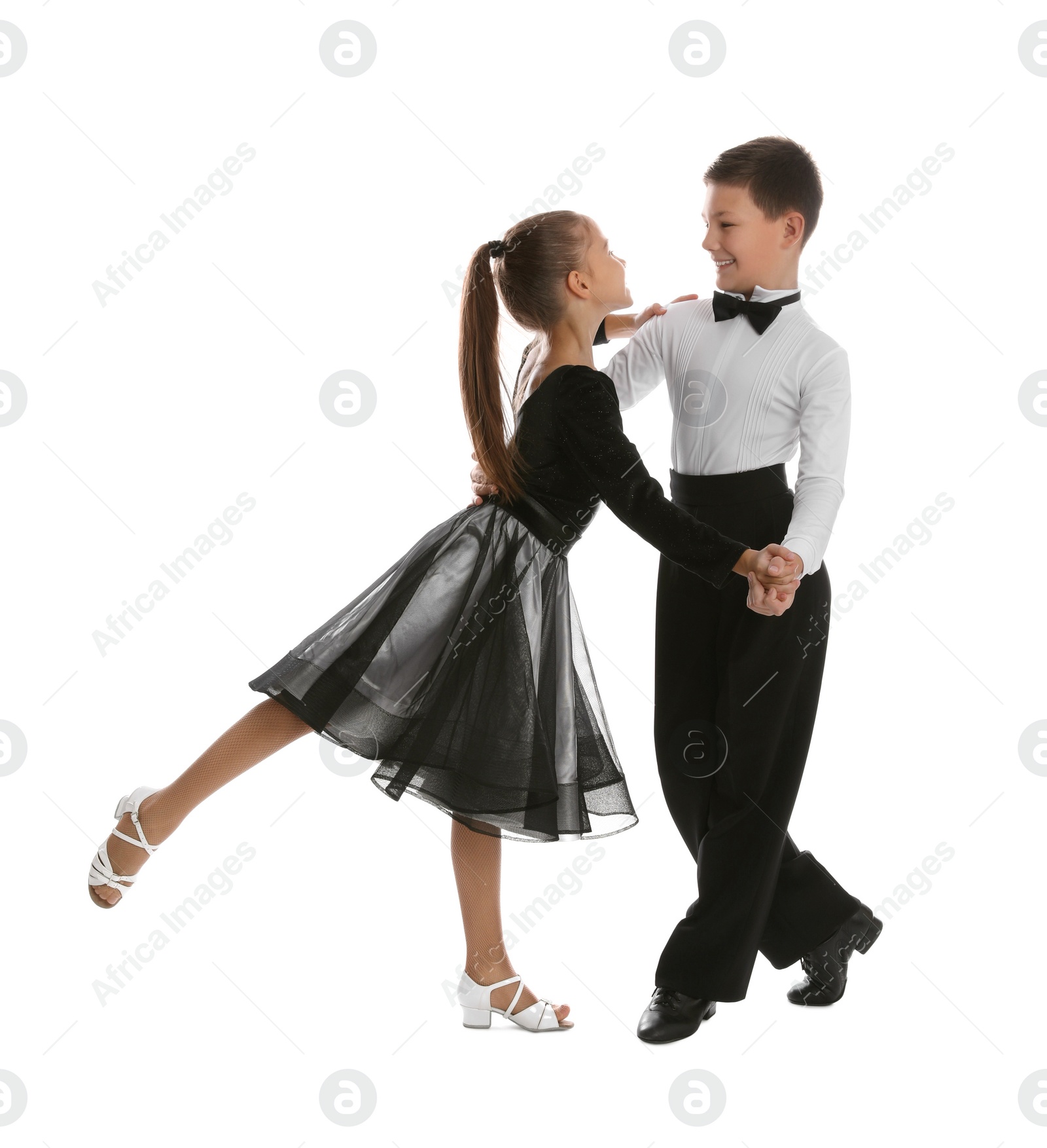 Photo of Beautifully dressed couple of kids dancing on white background