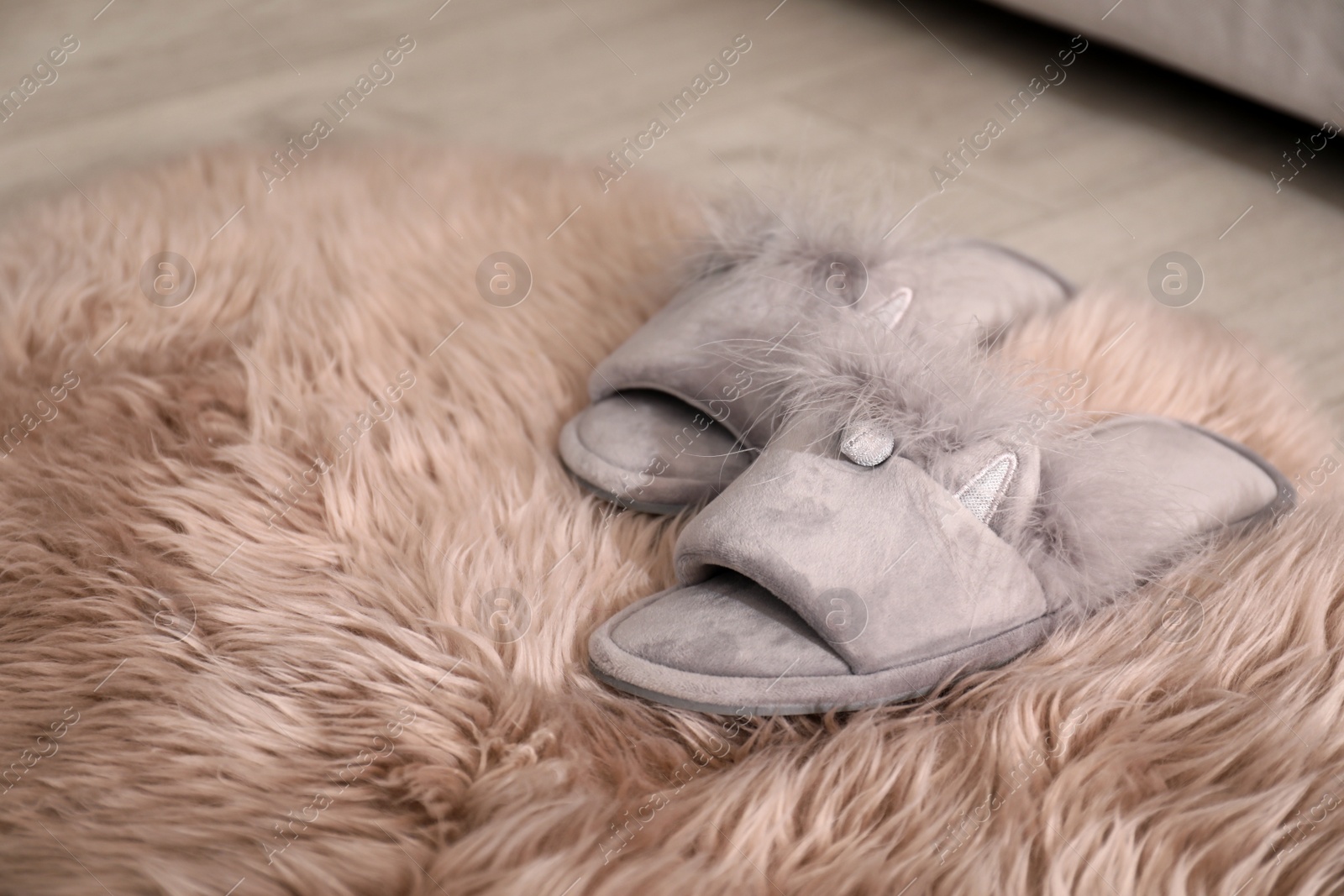 Photo of Pair of light grey slippers on floor in room