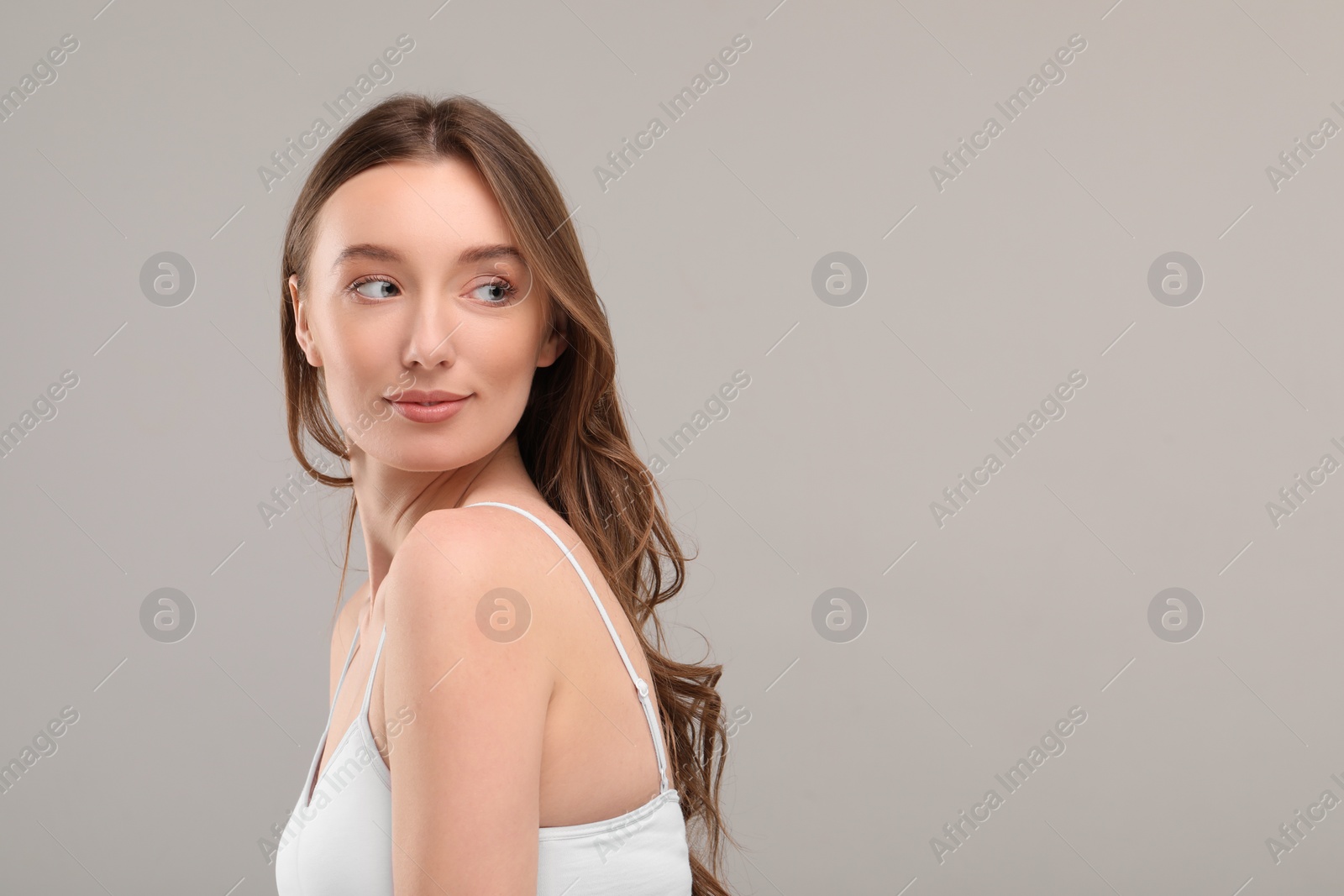 Photo of Beautiful woman with healthy skin on gray background, space for text