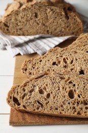 Photo of Freshly baked cut sourdough bread on white wooden table