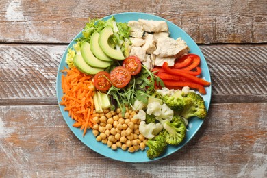 Balanced diet and healthy foods. Plate with different delicious products on wooden table, top view