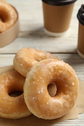 Sweet delicious donuts on white wooden table