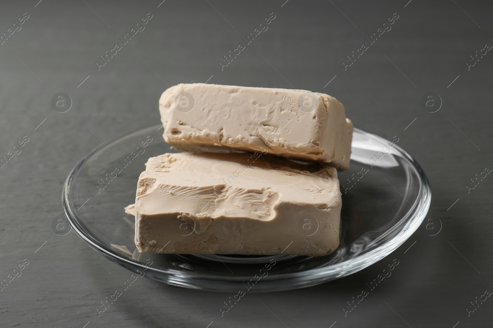 Photo of Fresh compressed yeast on grey wooden table