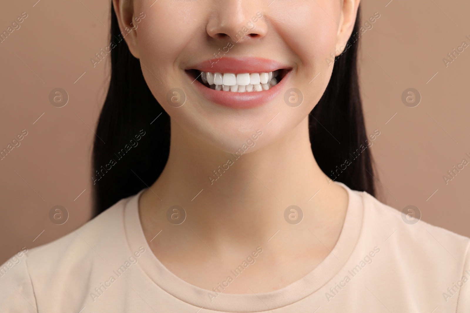 Photo of Woman with clean teeth smiling on beige background, closeup