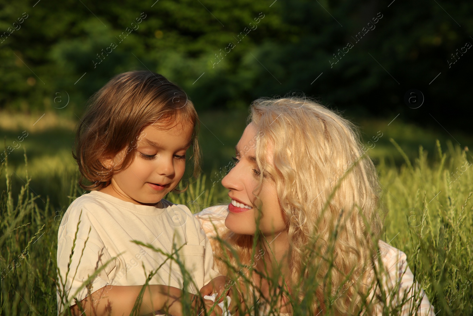 Photo of Beautiful mother with her cute daughter spending time together outdoors