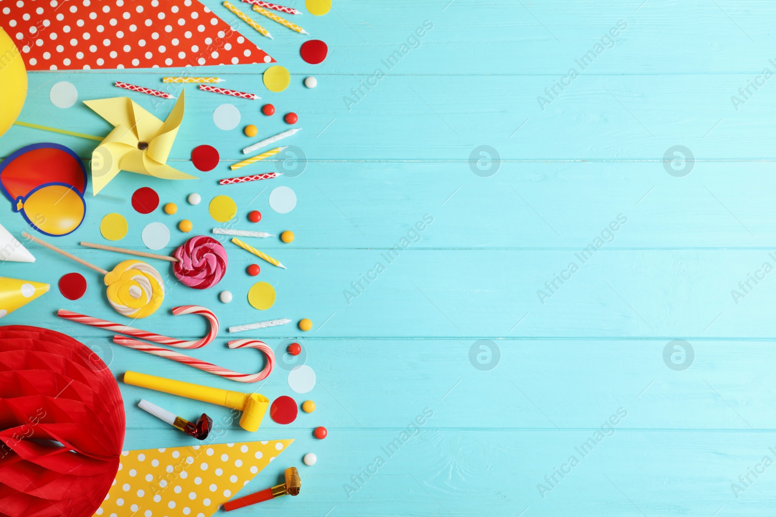 Photo of Colorful birthday accessories on blue wooden background, flat lay. Space for text