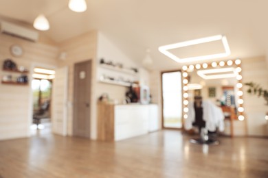 Photo of Blurred view of stylish barbershop interior with professional hairdresser's workplace