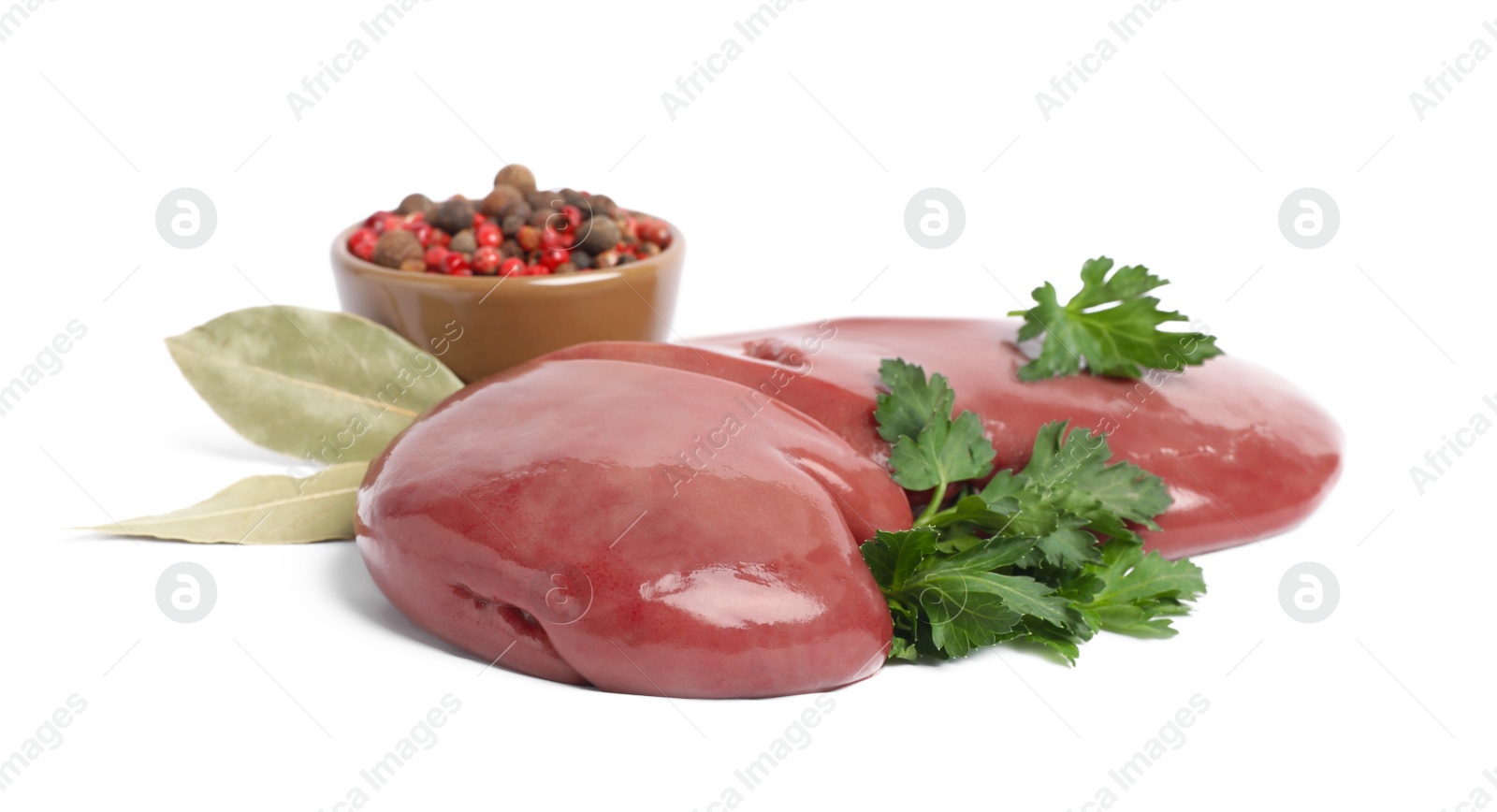 Photo of Fresh raw pork kidney with parsley, bay leaves and peppercorns on white background