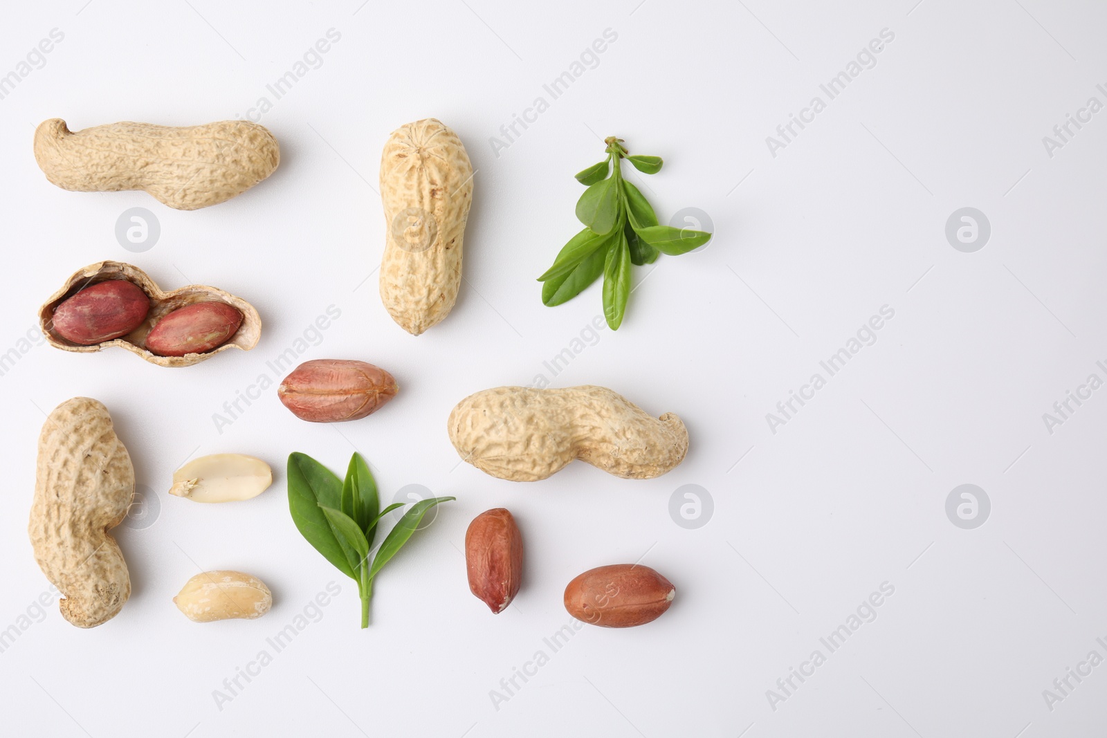 Photo of Fresh peanuts and leaves on white table, flat lay. Space for text