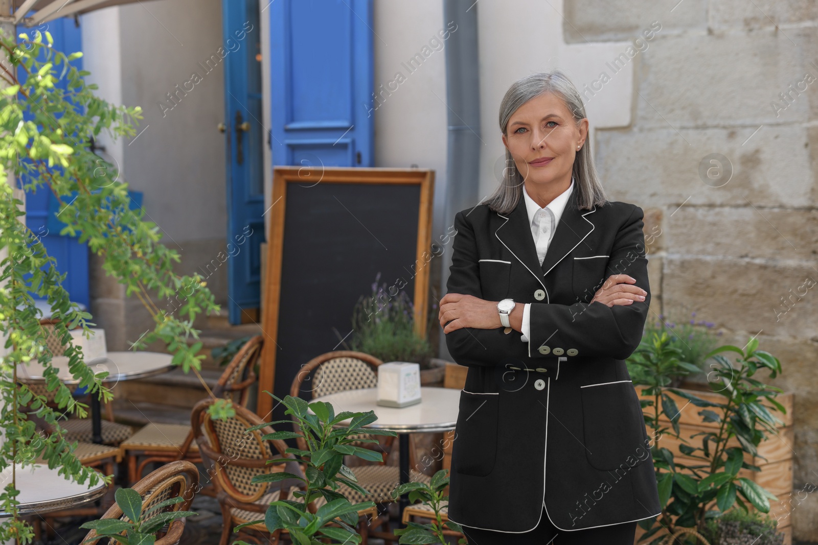 Photo of Beautiful business owner near her cafe outdoors, space for text