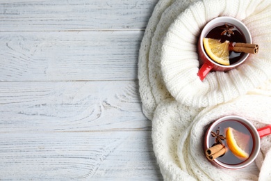 Photo of Flat lay composition with cups of hot winter drink on white wooden table. Space for text